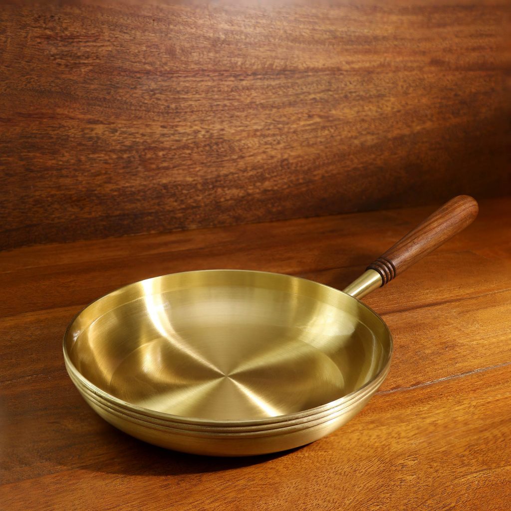 https://www.architectandinteriorsindia.com/cloud/2021/12/06/Arra-Brass-Frying-Pan-With-Wooden-Handle-2-1024x1024.jpg